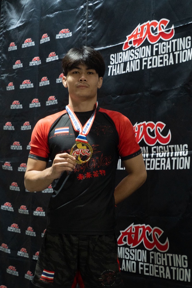 A Gato Studio BJJ competitor in team colours with an ADCC Thailand Federation gold medal